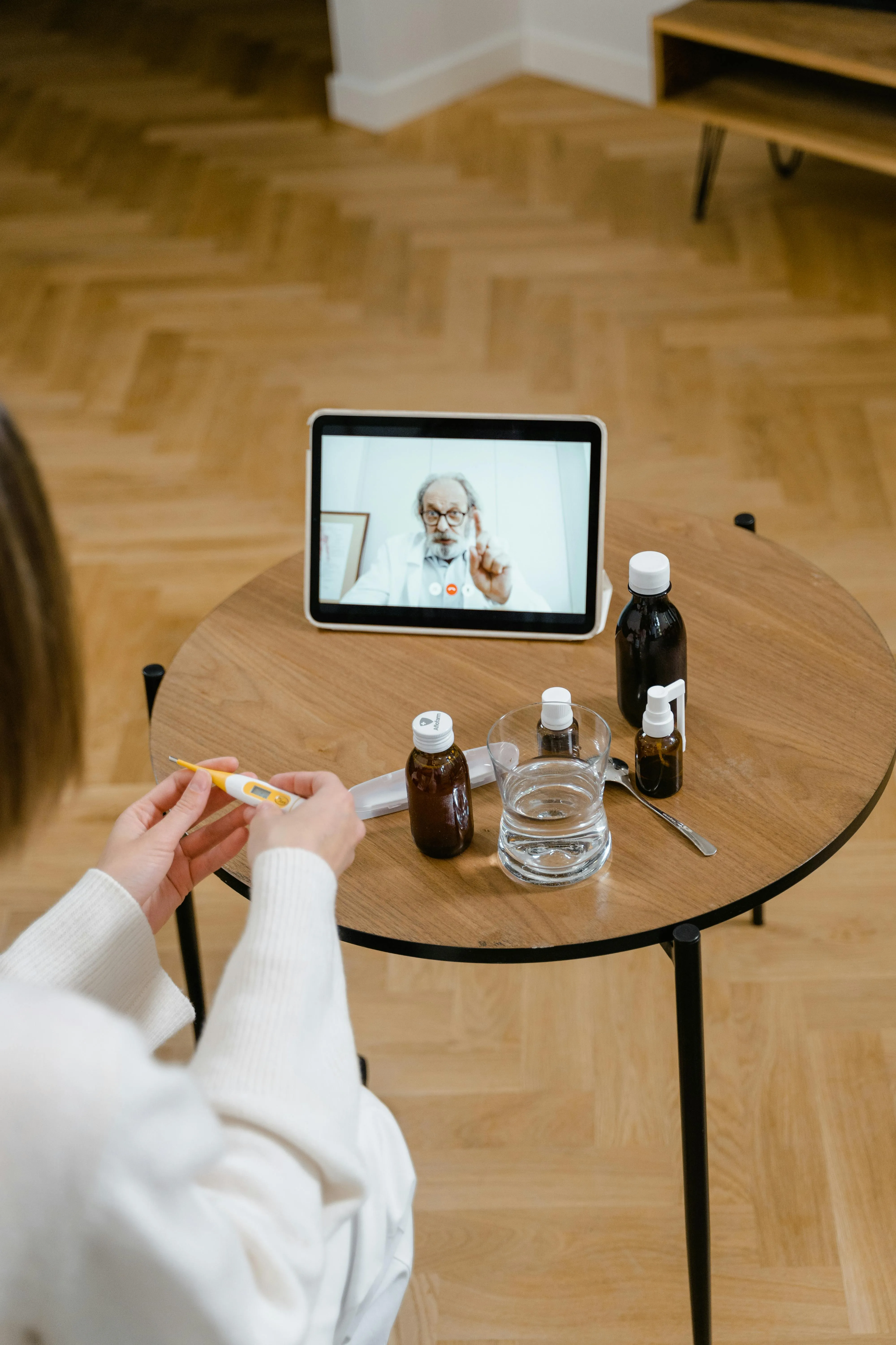 Një pacient merr një konsultë mjekësore në distancë përmes një tableti, me mjekun që shfaqet në ekran, simbol i telemedicinës moderne.
